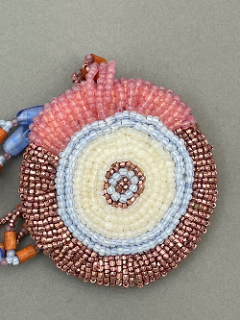 Details of the pendant and its embroidered micro beads